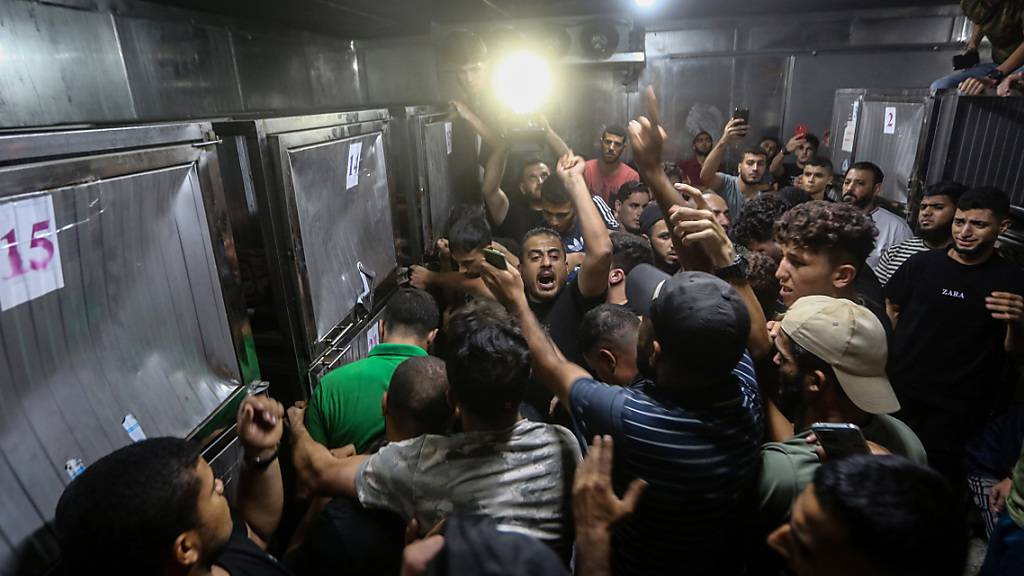 Palästinenser drängen sich am Grenzzaun zwischen Israel und Gaza in einer Leichenhalle eines Krankenhauses. Foto: Mohammed Talatene/dpa