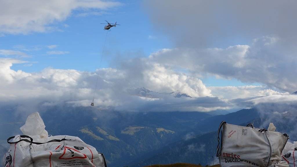 Ein Helikopter transportiert die Grasplatten für ein Experiment über Alpenpflanzen am Calanda.