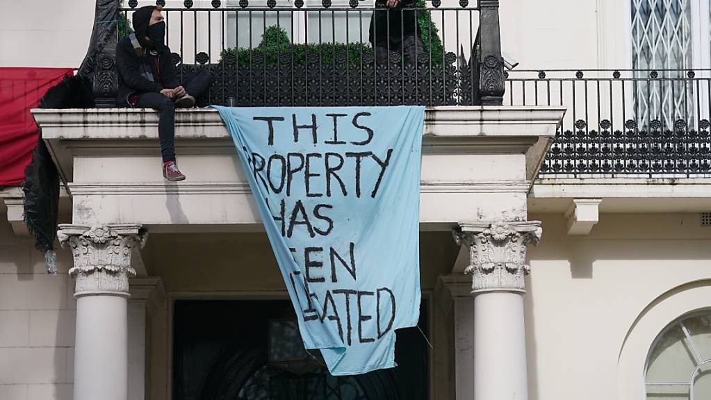 Aktivisten stehen auf dem Balkon der Stadtvilla des russischen Oligarchen Deripaska am Belgrave Square. Londons Bürgermeister forderte Immobilien der Oligarchen für ukrainische Flüchtlinge zu öffnen. Foto: Jonathan Brady/PA Wire/dpa