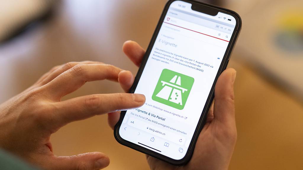 Eine Frau löst am 1. Dezember auf ihrem Smartphone eine elektronische Autobahnvignette.