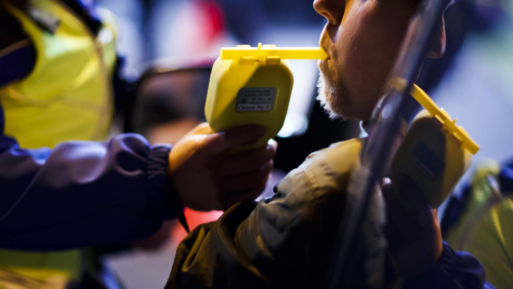 Blaufahrt_Alkoholtest_Polizeikontrolle-A man blows in a breathalyzer as Geneva police officers and border patrol members control drivers for alcohol and drug consumption, in Perly near Geneva, Thursday, late December 21, 2017. «Nez Rouge», a prevention campaign and driver service that offers to drive people home free of charge when under influence, aims to raise awareness on their services by joining the police on this control as Christmas and New-Year celebrations approach.