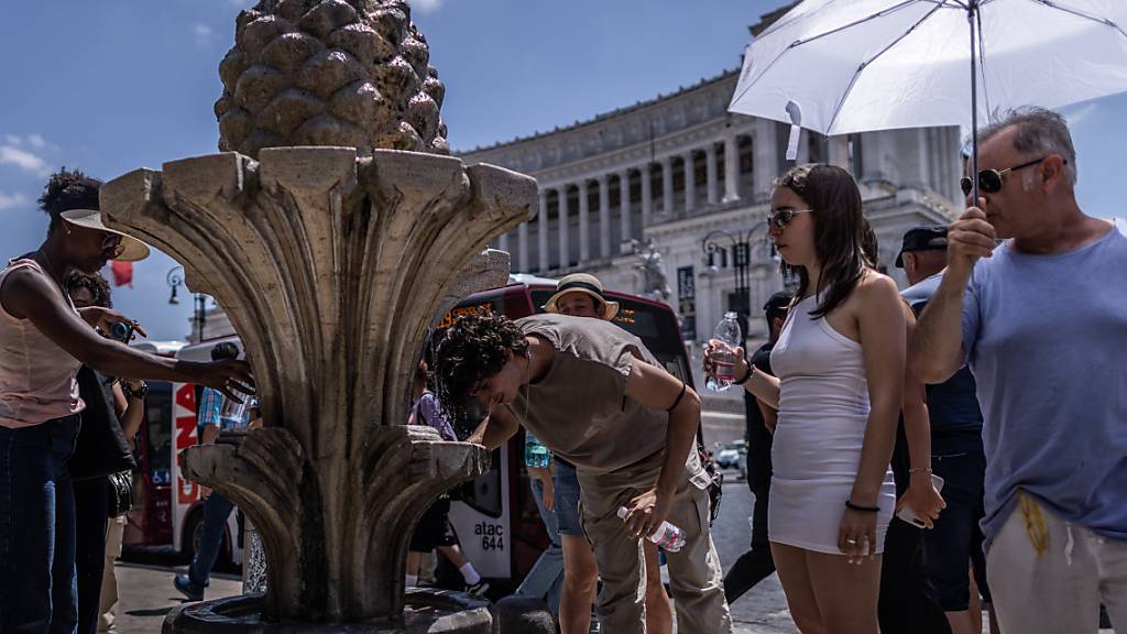 Touristen in Rom versuchen, sich abzukühlen. Die Hitzewelle kann dieses Wochenende Temperaturrekorde brechen. Foto: Oliver Weiken/dpa