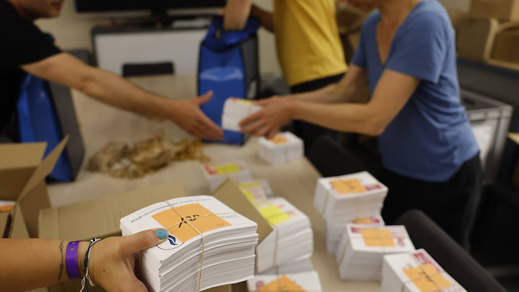 Beamte der Stadtverwaltung bereiten die Wahlunterlagen für die Parlamentswahlen in Straßburg vor. Foto: Jean-Francois Badias/AP/dpa
