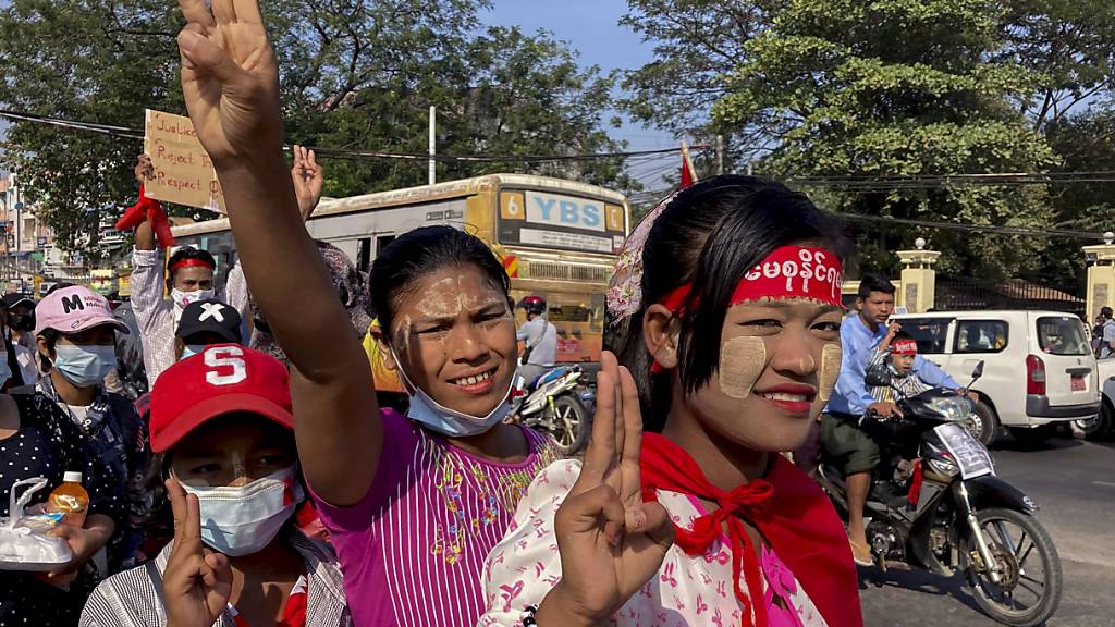 Demonstranten machen den Dreifingergruß als Symbol des Widerstandes gegen den Militärputsch. Ungeachtet internationaler Appelle, Sanktionen und Großdemonstrationen geht die neue Militärjunta in Myanmar weiter hart gegen die entmachtete zivile Regierung vor. Foto: Str/AP/dpa