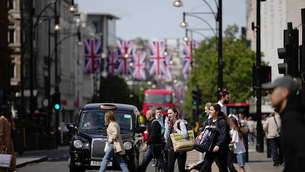 ARCHIV - Menschen gehen am Mittwoch in London durch das Einkaufsviertel an der Oxford Street. Foto: Matt Dunham/AP/dpa