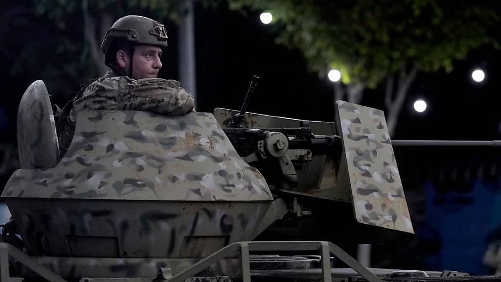 Ein Soldat der libanesischen Armee sitzt hinter seiner Waffe auf dem Dach eines gepanzerten Mannschaftstransporters am Ort eines israelischen Luftangriffs in einem südlichen Vorort. Foto: Bilal Hussein/AP