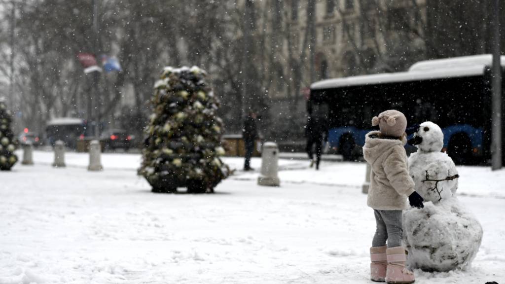 Ein Mädchen spielt mit einem Schneemann auf der Straße in Madrid. Das Sturmtief «Filomena» sorgt im Sonnenland Spanien für Rekordkälte, viel Schnee und einiges Chaos. Foto: Óscar Cañas/EUROPA PRESS/dpa