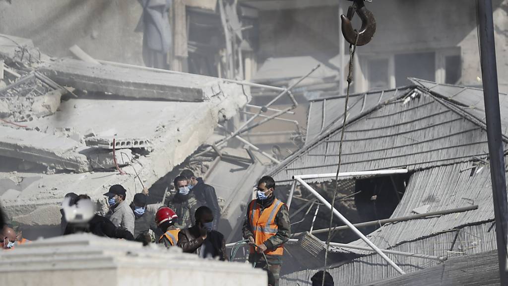 dpatopbilder - Rettungskräfte arbeiten an einem von einem Luftangriff getroffenen Gebäude. Foto: Omar Sanadiki/AP/dpa