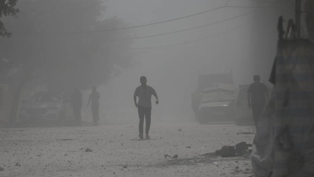 ARCHIV - Palästinenser laufen durch Staub nach einem israelischen Militärschlag (Archivbild). Foto: Yousef Al Zanoun/AP/dpa