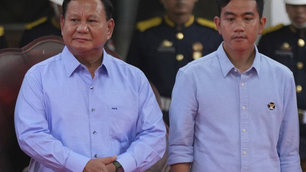 Präsidentschaftskandidat Prabowo Subianto (l) und sein Kandidat zum Vize-Präsidenten Gibran Rakabuming Raka stehen auf der Bühne während der Unterzeichnungszeremonie der «Erklärung für einen friedlichen Wahlkampf» im Gebäude der Allgemeinen Wahlkommission. Foto: Tatan Syuflana/AP/dpa