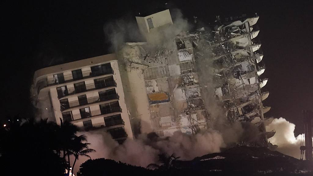 Die beschädigte Reststruktur des Champlain Towers South Condo Gebäudes stürzt ein. Nach dem Teileinsturz des Wohnkomplexes in der Nähe von Miami ist der noch stehende Gebäudeteil gesprengt werden. Die Ruine war instabil. Foto: Lynne Sladky/AP/dpa Foto: Lynne Sladky/AP/dpa