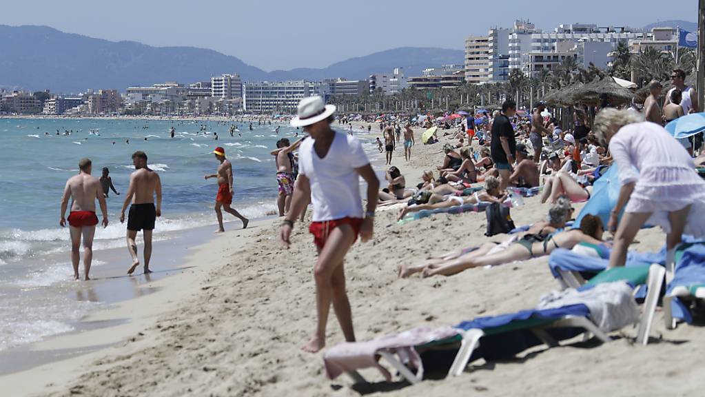 Touristen halten sich am Strand von Arenal in Palma de Mallorca auf.