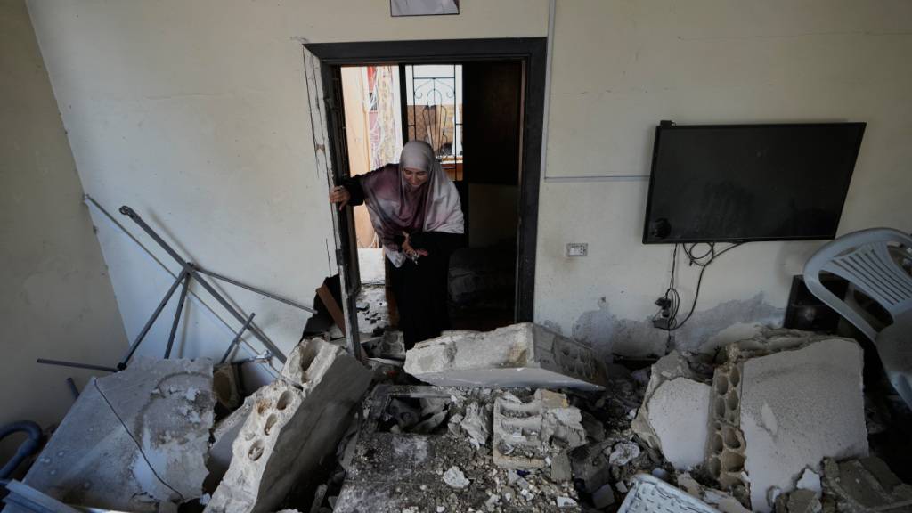 dpatopbilder - Eine Frau betritt ihr Haus, das bei einem israelischen Luftangriff im Dorf Burj al-Shemali in der Nähe der südlichen Hafenstadt Tyrus zerstört wurde. Foto: Mohammed Zaatari/AP/dpa