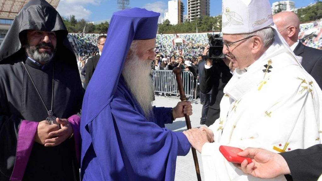 Papst Franziskus begrüsst orthodoxe Kleriker, die an seiner Messe im Micheil-Meschi-Stadion von Tiflis teilnahmen.
