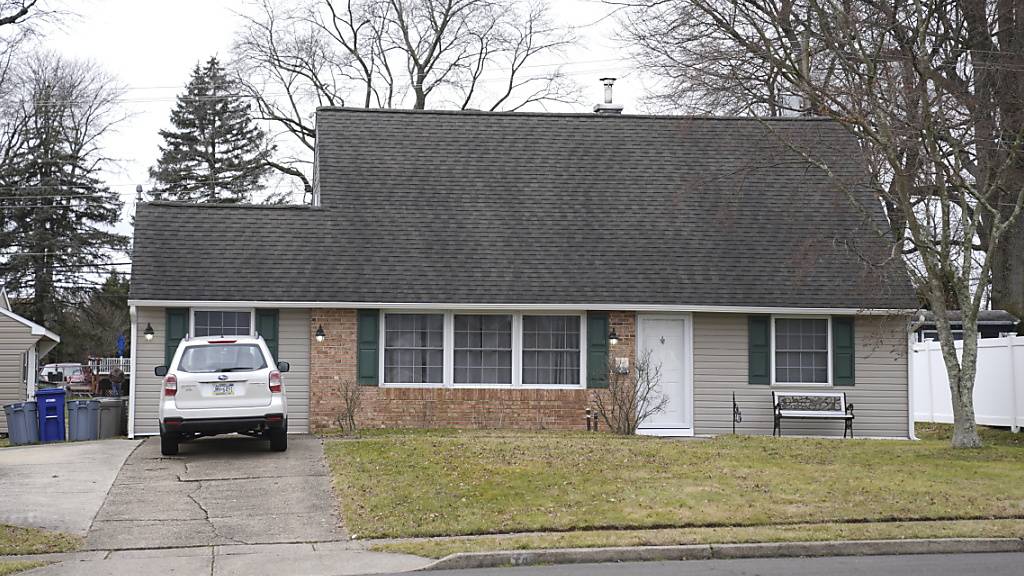 Ein Fahrzeug ist in der Einfahrt eines Hauses geparkt, das Schauplatz eines Mordes war. Foto: Matt Rourke/AP/dpa