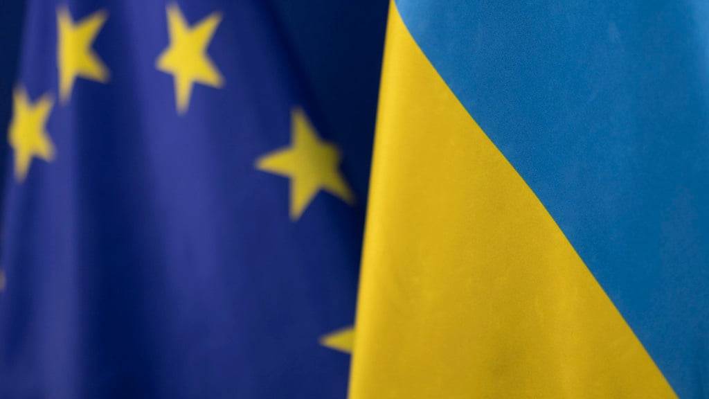 ARCHIV - Die Fahne der Ukraine steht vor der Flagge der europäischen Union. Foto: Christoph Reichwein/dpa