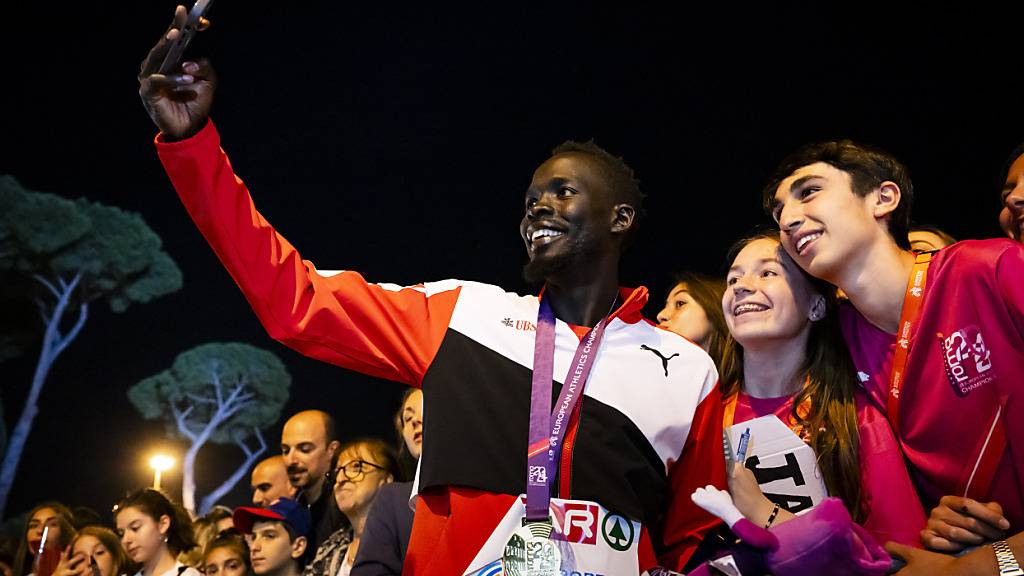 Dominic Lobalu mit der Goldmedaille um den Hals macht ein Selfie nach der Siegerehrung