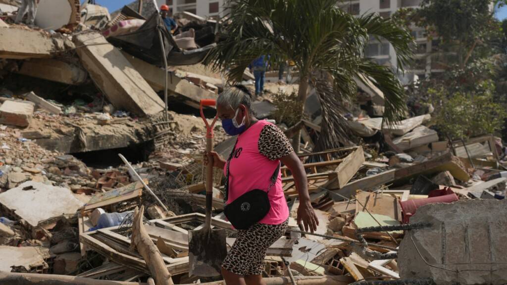 Anwohner durchsuchen die Trümmer eines Gebäudes in La Guaira. Foto: Matias Delacroix/AP/dpa