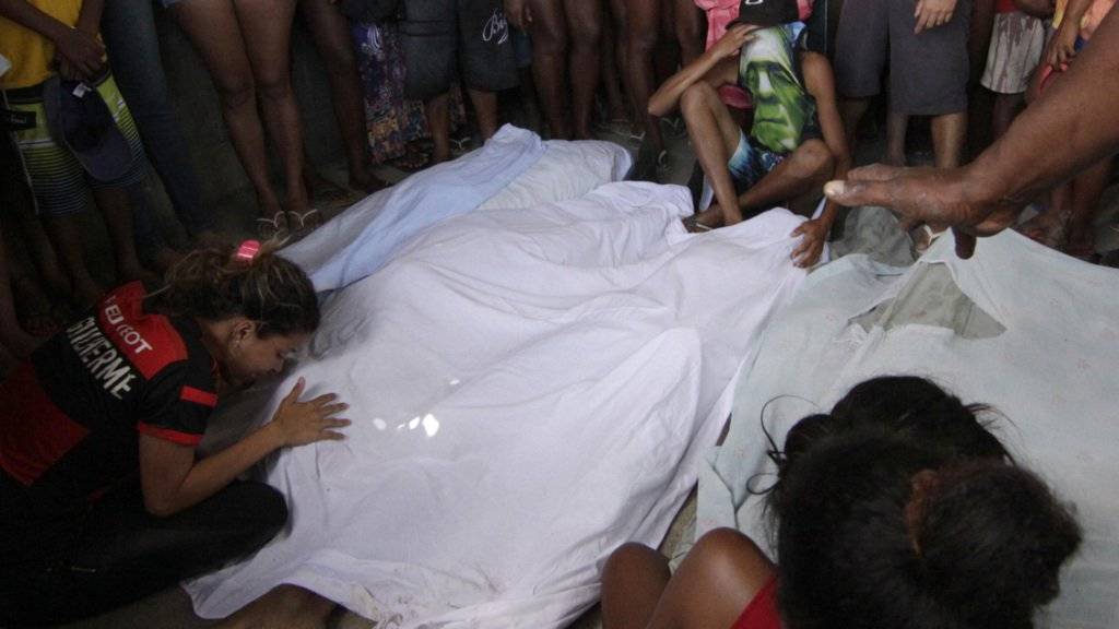 Angehörige trauern um die sieben Männer, die in einem sumpfigen Gelände in Rio de Janeiro tot aufgefunden wurden.