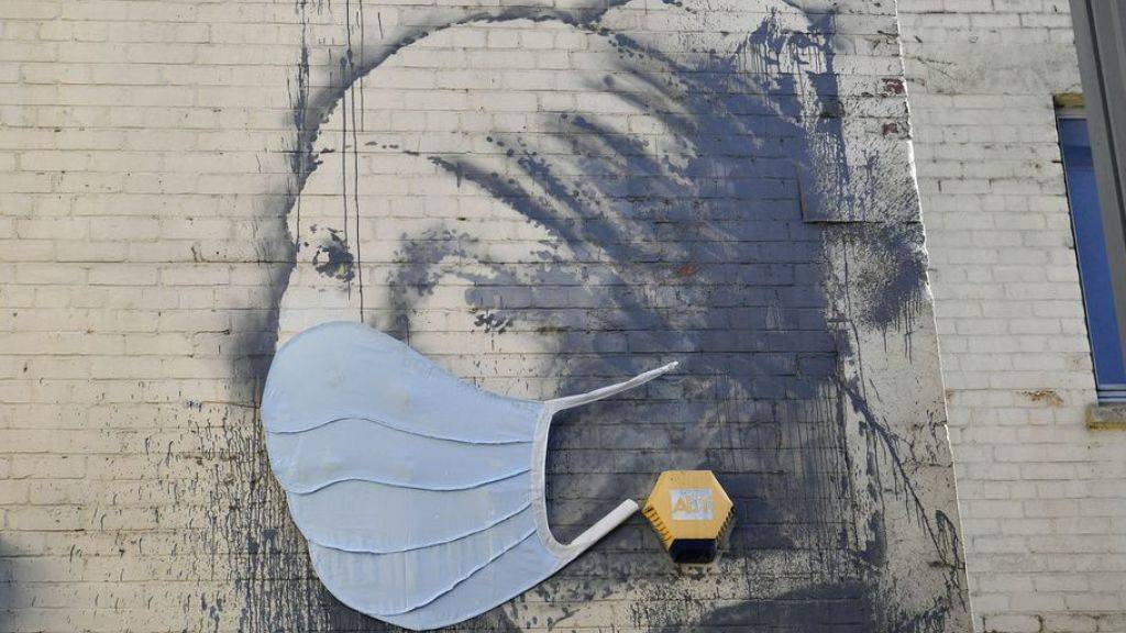 Banksys Streetart-Version von Vermeers «Mädchen mit dem Perlenohrring» wurde aus Gründen der Aktualität mit einem Mundschutz versehen. Indessen haben Forscher das Originalbild untersucht und überraschende Entdeckungen gemacht. (Archivbild 22.4.)