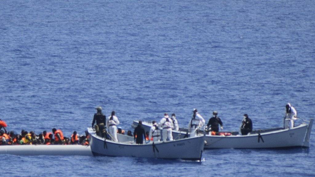 Die italienische Küstenwache rettet Flüchtlinge aus einem überfüllten Schlauchboot. In den letzten Tagen sind erneut über 4000 Flüchtlinge aus dem Mittelmeer gerettet worden. (Archiv)