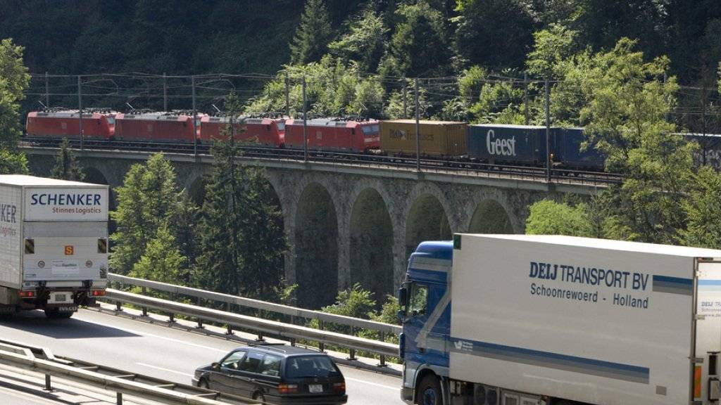 Ein Güterzug ist auf der Gotthardstrecke bei Gurtnellen unterwegs - auf der parallel verlaufenden Autobahn fahren Lastwagen in Richtung Süden (Archivbild).