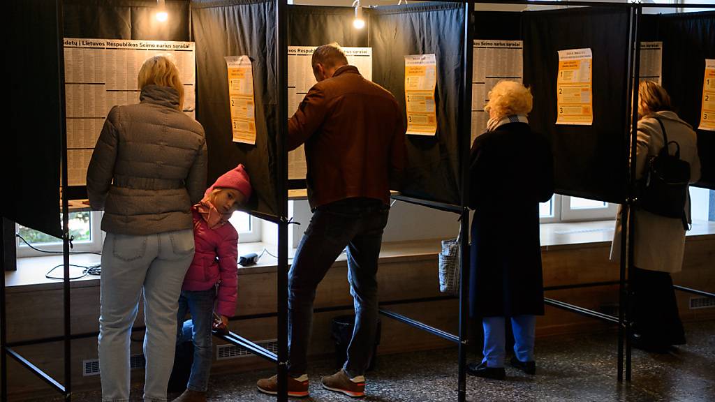 Wähler füllen ihre Stimmzettel in einem Wahllokal während des ersten Wahlgangs der Parlamentswahlen aus. In Litauen findet die erste Runde der Parlamentswahlen zum Seimas statt. Foto: Yauhen Yerchak/SOPA Images via ZUMA Press Wire/dpa