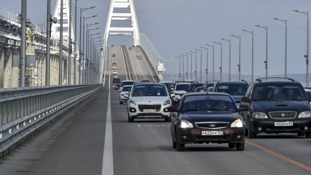 ARCHIV - Autos und andere Fahrzeuge fahren auf der Krim-Brücke, die das russische Festland und die Halbinsel Krim über die Meerenge von Kertsch nach Restaurierungsarbeiten wieder verbindet. Foto: Uncredited/AP/dpa