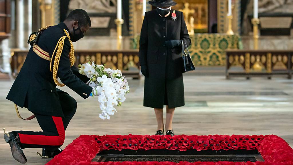 Der Stallmeister der britischen Königin legt im Namen von Königin Elizabeth II. während einer Zeremonie in der Londoner Westminster Abbey ein Blumenbukett am Grab des Unbekannten Soldaten nieder. Die Queen ist erstmals mit Mund-Nasen-Schutz in der Öffentlichkeit aufgetreten. Foto: Aaron Chown/PA Wire/dpa