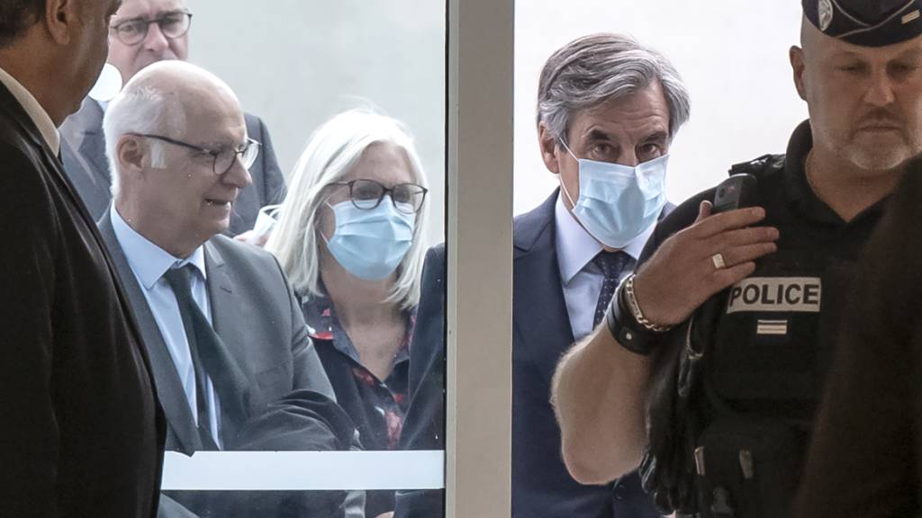 Francois Fillon (Mitte, r), ehemaliger Premierminister von Frankreich, und seine Frau Penelope (Mitte, l) beim Eintreffen im Gerichtsgebäude. Foto: Michel Euler/AP/dpa
