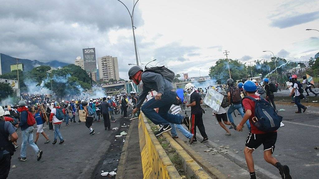 In Caracas flüchten Demonstranten vor Sicherheitskräften.