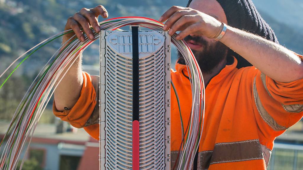 Ein Arbeiter montiert Glasfaserkabel der Swisscom. Der Ausbau der Breitbanderschliessung in ländlichen Gebieten ist durch einen Gerichtsentscheid behindert. Betroffen ist auch ein Projekt in Appenzell Innerrhoden. (Symbolbild)