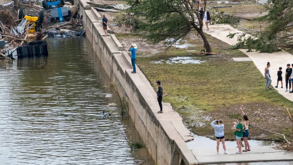 Schaulustige spazieren am Ufer des Guadalupe River im Louise Hays Park, in Kerrville, Texas. Foto: Rodolfo Gonzalez/AP/dpa