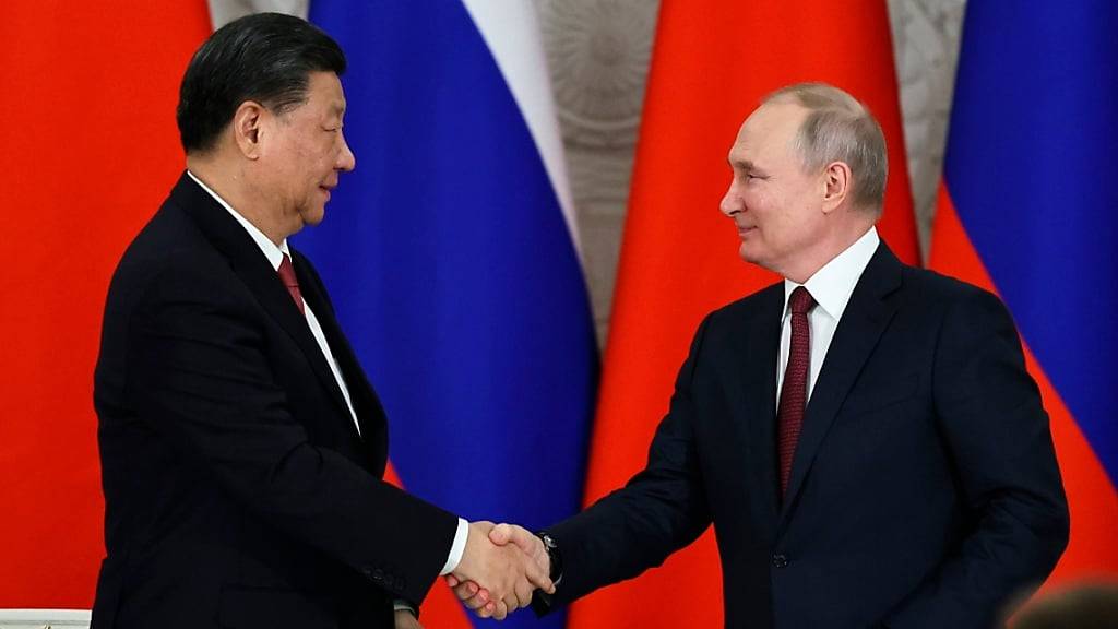 ARCHIV - Russlands Präsident Wladimir Putin (r) und  Chinas Staats- und Parteichef Xi Jinping schütteln sich nach einem Treffen im März die Hände. Foto: Mikhail Tereshchenko/Sputnik Kremlin Pool via AP/dpa/Archiv