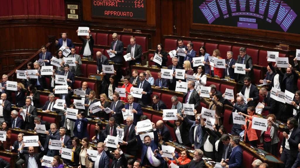 Abgeordnete protestieren, während auf einer Anzeigetafel die Ergebnisse der Schlussabstimmung über den Gesetzentwurf zum Wahlrecht in der Abgeordnetenkammer in Rom angezeigt werden. Foto: Andrew Medichini/AP/dpa