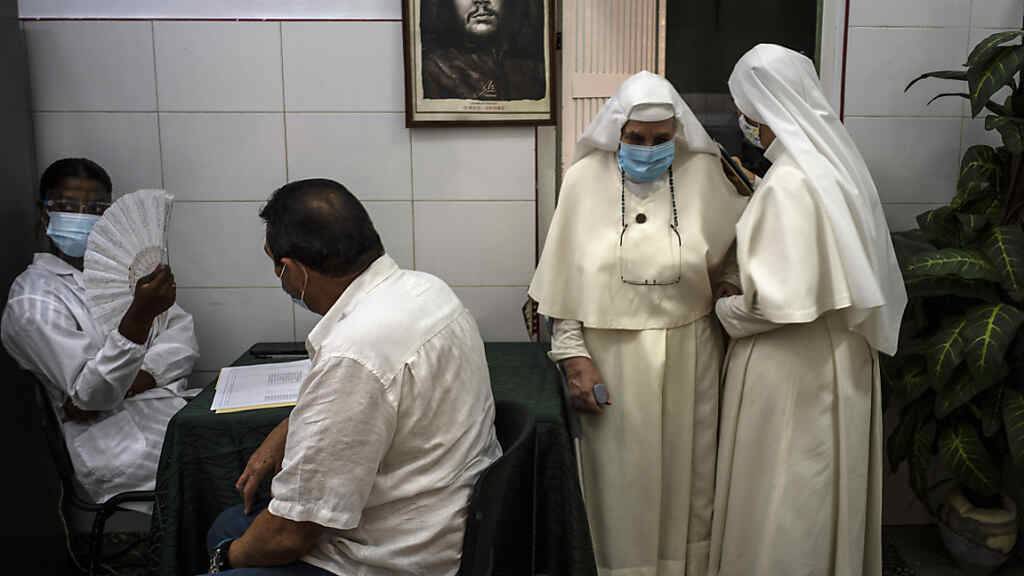 In Havana verlassen zwei Nonnen ein Impfzentrum, nachdem ihnen eine Dosis des kubanischen Corona-Impfstoffs Abdala verabreicht wurde. Foto: Ramon Espinosa/AP/dpa