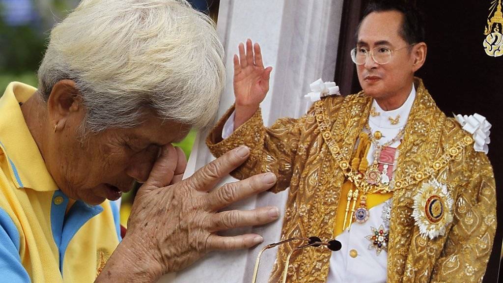 Ein Thailänder betet vor einem Bild von König Bhumibol. Der als gottähnlich verehrte Monarch feiert seinen 88. Geburtstag.
