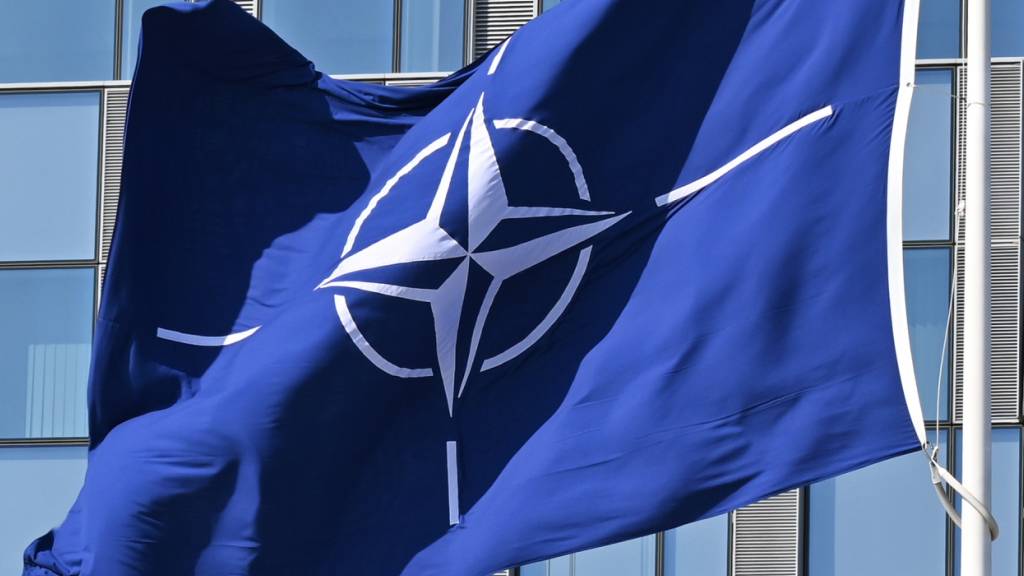 SYMBOLBILD - Eine Flagge der Nato weht im Wind. Foto: Anna Ross/dpa/Symbolbild