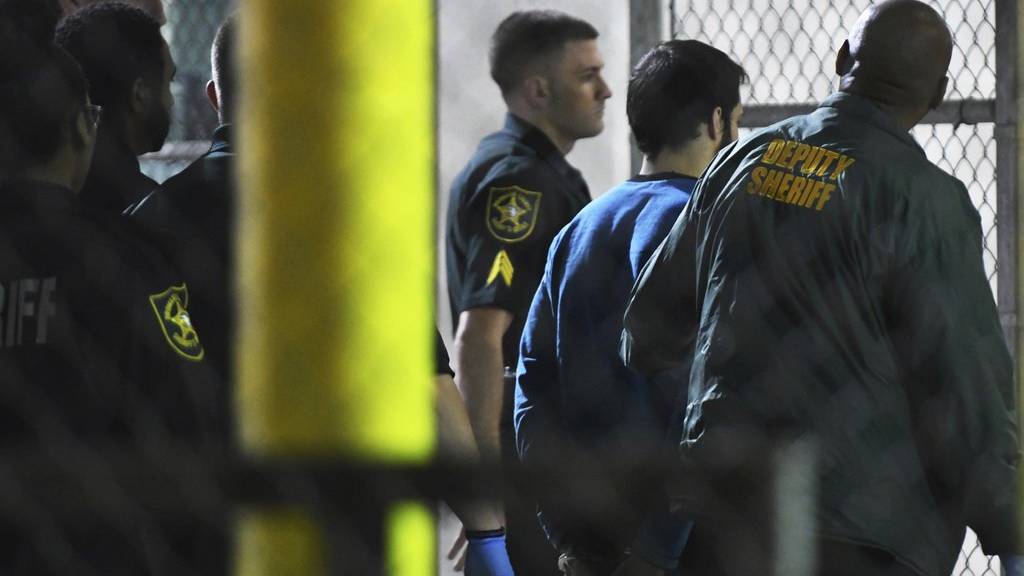 Polizisten führen den mutmasslichen Täter am Flughafen in Fort Lauderdale ab