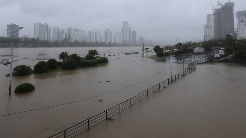 Ein Teil einer Straße und ein Flussufer sind überflutet, nachdem der Tropensturm «Khanun» auf Land traf.  Mindestens ein Mensch kam in der südöstlichen Großstadt Daegu ums Leben, wie die nationale Nachrichtenagentur Yonhap am Donnerstag berichtete. Foto: Kim Yong-tae/Yonhap/AP/dpa