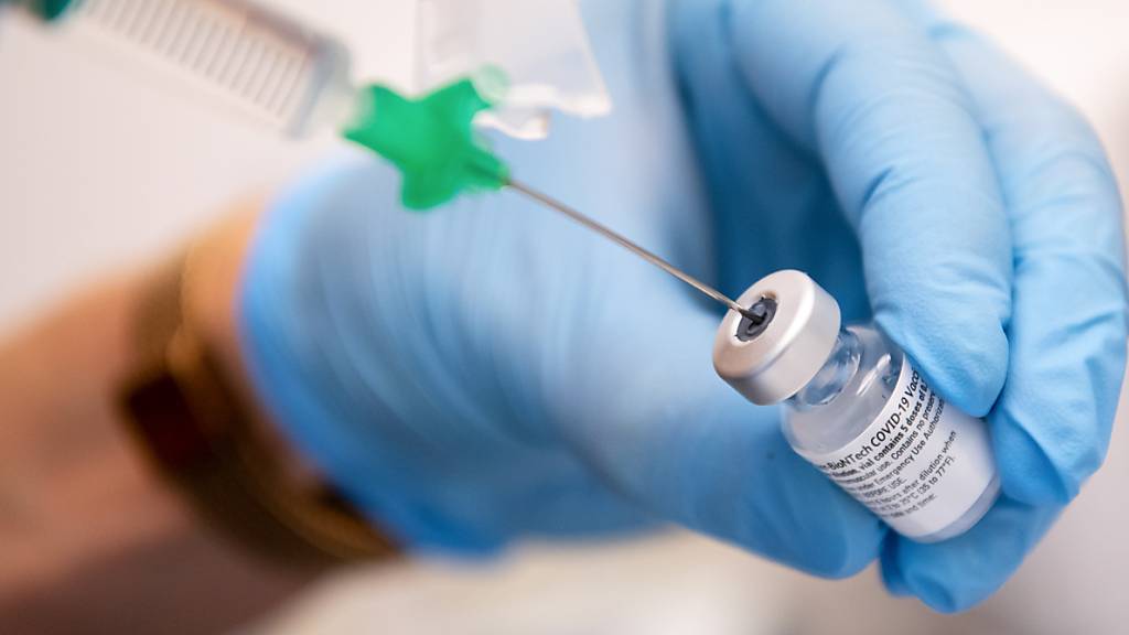 Eine Klinik-Mitarbeiterin zieht den Covid-19 Impfstoff von Biontech/Pfizer für eine Impfung auf eine Spritze. Ab sofort können mehr Menschen mit dem Impfstoff aus einer Ampulle der Hersteller Biontech und Pfizer geimpft werden. (Archiv)