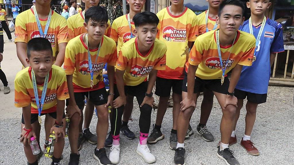 Mitglieder der in einer thailändischen Höhle eingeschlossenen Fussballmannschaft posieren nach einem Wohltätigkeitslauf ein Jahr nach dem Höhlenunglück.