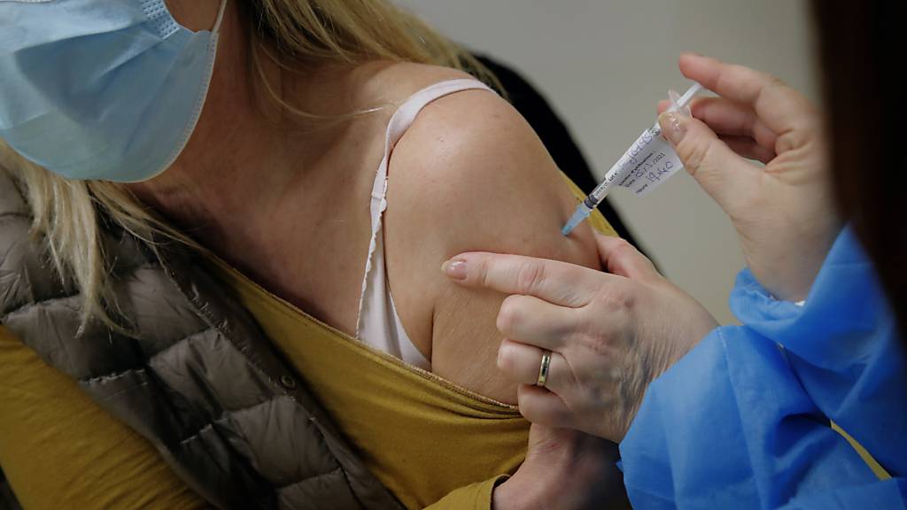 Eine Mitarbeiterin des Gesundheitswesens wird mit dem Pfizer/Biontech-Impftoff gegen das Coronavirus geimpft. Foto: Christophe Ena/AP/dpa