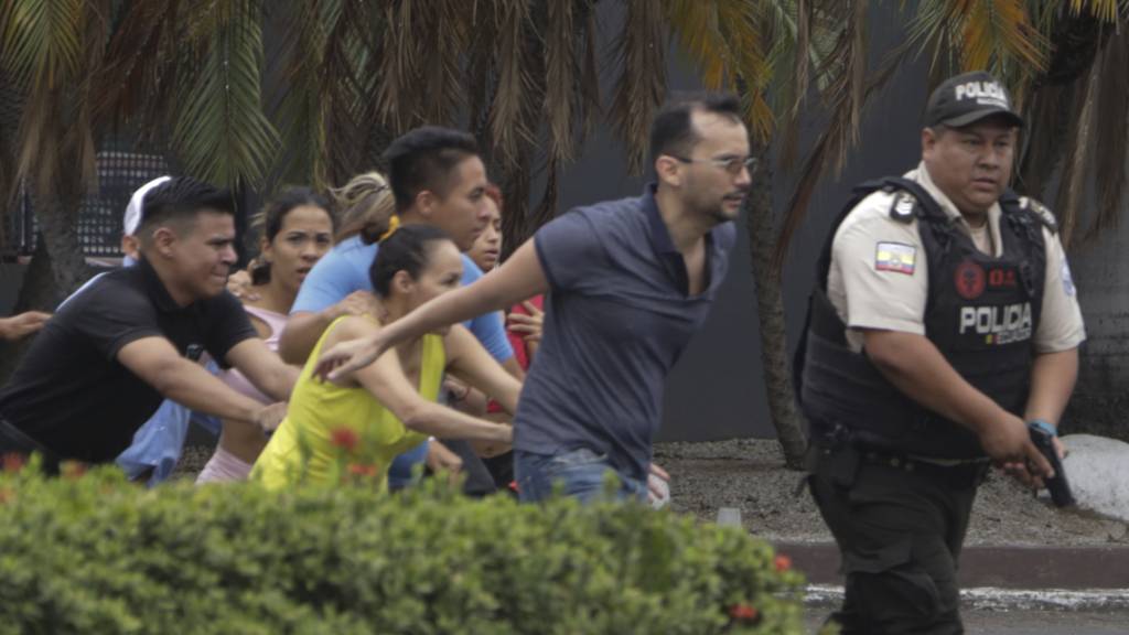 Die Polizei evakuiert Mitarbeiter des Fernsehsenders TC, nachdem eine Gruppe bewaffneter Männer während einer Live-Übertragung in das Studio eingedrungen war. Mehrere Menschen wurden mit Maschinengewehren und Sprengstoff bedroht und als Geiseln genommen. Foto: Cesar Munoz/AP