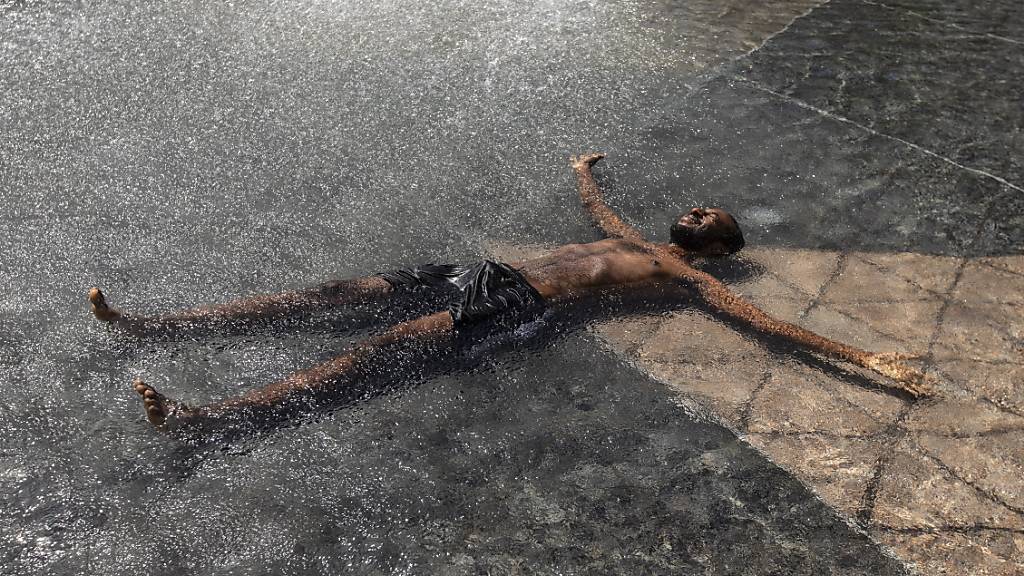 Kais Bothe entspannt und kühlt sich in einem Pool des Rathauses ab. Die anhaltende Hitzewelle im Westen Kanadas hat für neue Höchsttemperaturen gesorgt und zu mehreren Todesfällen beigetragen. Foto: Jason Franson/The Canadian Press/AP/dpa