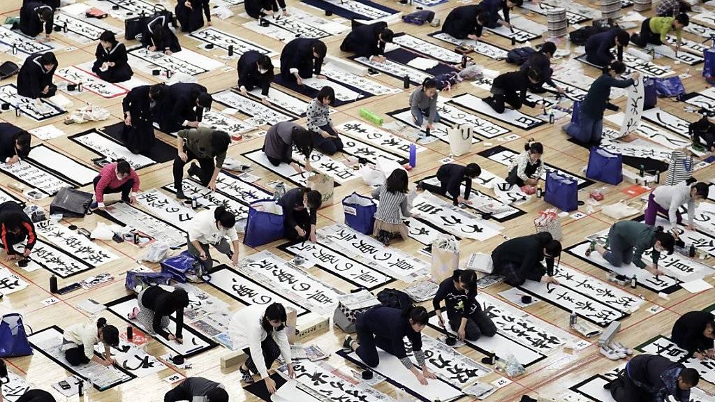 Bei einem Kaligraphie-Wettbewerb in Tokio bemühen sich rund 3000 Japaner um die kunstvollsten Schriftzeichen.