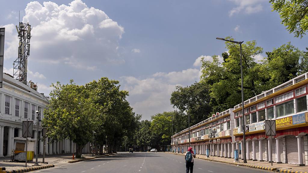 Eine Frau überquert eine Straße, während der Verkehr vor dem G20-Gipfel am Wochenende (09./10. September) eingeschränkt und umgeleitet wird. Foto: Altaf Qadri/AP/dpa