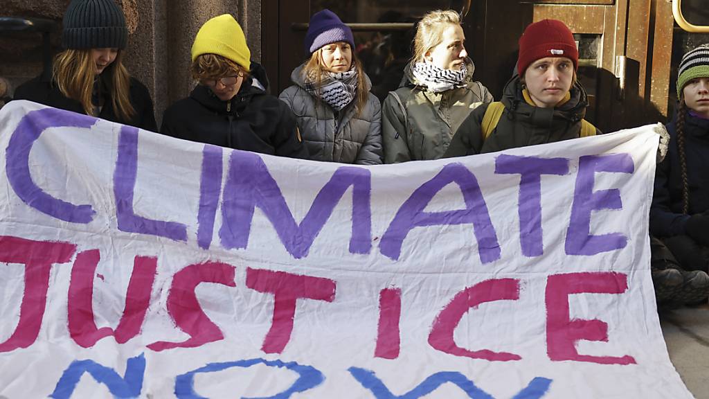 dpatopbilder - Die Klimaaktivistin Greta Thunberg (3.v.l.) und andere Demonstrierende blockieren während einer Protestaktion mit einem Transparent den Eingang des schwedischen Parlaments in Stockholm. Foto: Christine Olsson/TT/TT News Agency/AP