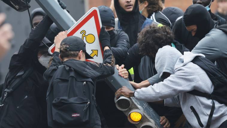 Schüler reißen eine Ampel neben dem Baggio-Gymnasium nieder, das aus Protest gegen die Veröffentlichung des Haushaltsentwurfs für das nächste Jahr durch die Regierung blockiert wurde. Beschäftigte des öffentlichen Dienstes führen in ganz Frankreich einen eintägigen Streik und Demonstrationen durch. Foto: Jean-Francois Badias/AP/dpa