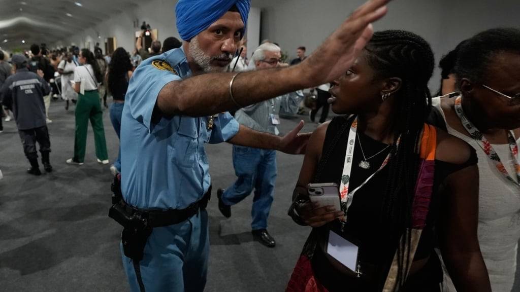 dpatopbilder - Ein Sicherheitsbeamter weist Menschen an, den Veranstaltungsort der Weltklimakonferenz COP30 zu verlassen. Foto: Fernando Llano/AP/dpa